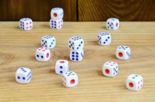 A few dice lies on the surface of natural wood. Items for generating numbers from one to six in the form of points that are painted on the side of cubes. The concept of gambling photo