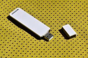 A modern portable USB wi-fi adapter is placed on the yellow sportswear made of polyester nylon fiber photo
