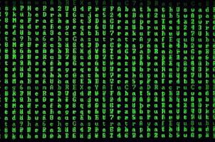 Macro shot of a glitch on the monitor of an office computer. The concept of introducing a virus into a personal data keeper. Stream of random green symbols on a black background photo