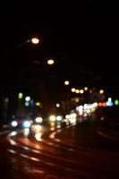 Blurred night scene of traffic on the roadway. Defocused image of cars traveling with luminous headlights. Bokeh Art photo