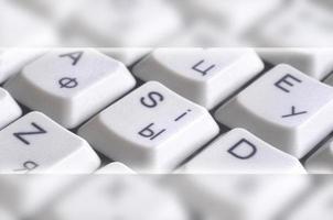 Close-up of the white computer classic keyboard with english and russian letters with copy space field photo