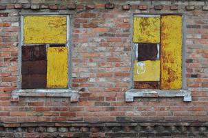 viejas ventanas entabladas en la pared de ladrillo foto