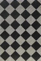 Plastic texture in the form of a very small cloth binding, painted in black and gray in the style of a chessboard. Macro shot photo