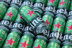 KHARKOV, UKRAINE - JULY 31, 2021 Green tin cans of Heineken lager beer produced by the Dutch brewing company Heineken N.V. photo