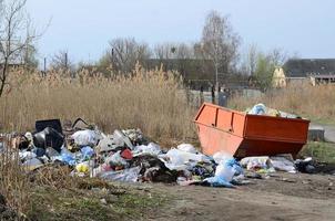 The garbage can is packed with garbage and waste. Untimely removal of garbage in populated areas photo