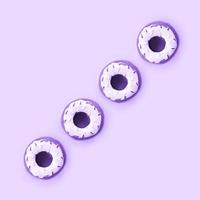 Many small plastic donuts lies on a pastel colorful background. Flat lay minimal pattern. Top view photo