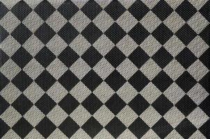 textura plástica en forma de encuadernación de tela muy pequeña, pintada en negro y gris al estilo de un tablero de ajedrez. tiro macro foto