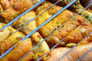 Marinated chicken legs on hot BBQ charcoal field grill photo