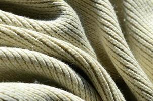Fabric texture of a soft yellow knitted sweater. Macro image of the structure of bindings in yarns photo