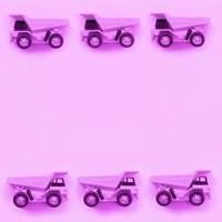 muchos pequeños camiones de juguete púrpura sobre fondo de textura de papel de color púrpura pastel de moda foto