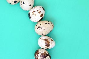 Quail eggs on a light green surface, top view, empty place for text, recipe photo