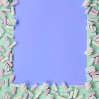 Colorful marshmallow laid out on green and lilac paper background photo