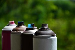 A few used aerosol paint sprayers lie on the windowsill in the workshop of a graffiti artist. The concept of street art and illegal drawing on the walls. Youth hobby photo