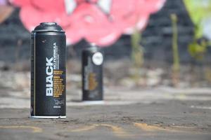 KHARKOV, UKRAINE - DECEMBER 9, 2020 Used Montana black aerosol spray cans against graffiti paintings. MTN or Montana-cans is manufacturer of high pressure spray paint goods photo
