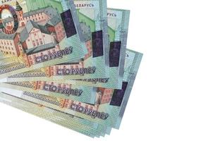 Los billetes de 100 rublos bielorrusos se encuentran en un pequeño grupo o en un paquete aislado en blanco. maqueta con espacio de copia. negocios y cambio de moneda foto