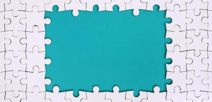 Framing in the form of a rectangle, made of a white jigsaw puzzle around the blue space photo