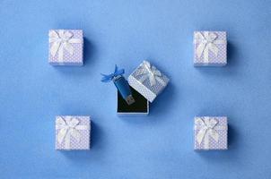 Brilliant blue usb flash memory card with a blue bow lies in a small gift box in blue with a small bow on a blanket of soft and furry light blue fleece fabric. Classic female gift memory card design photo