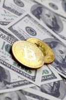 los bitcoins dorados yacen en muchos billetes de dólar. el concepto de elevar el precio de bitcoin en relación con el dólar estadounidense foto