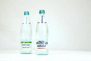 KHARKOV, UKRAINE - JULY 2, 2021 Glass of Borjomi brand of naturally carbonated mineral water from springs in Borjomi Gorge of central Georgia photo