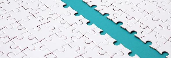 The blue path is laid on the platform of a white folded jigsaw puzzle. Texture image with copy space for text photo