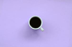 Small white coffee cup on texture background of fashion pastel violet color paper in minimal concept photo