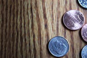 Dollar coins and dollar bills scattered on a wooden table, flat lay dollar coins. photo