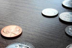 monedas de dólar esparcidas sobre una mesa de madera, foto