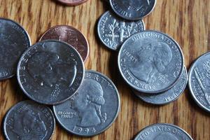 Dollar coins scattered on a wooden table, flat lay dollar coins. photo