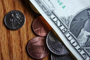 Dollar coins and dollar bills scattered on a wooden table, flat lay dollar coins. photo