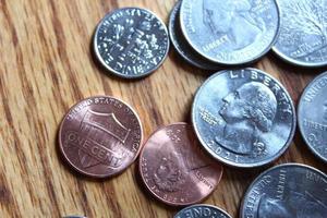 Dollar coins and dollar bills scattered on a wooden table, flat lay dollar coins. photo