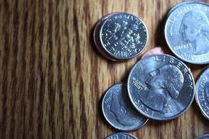 Dollar coins and dollar bills scattered on a wooden table, flat lay dollar coins. photo