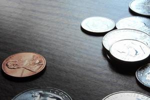 monedas de dólar esparcidas sobre una mesa de madera, foto