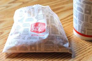 WASHINGTON, USA - MARCH, 15 2022  Jack in the box hamburgers, french fries and glasses served on a brown wooden table. photo