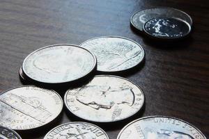 monedas de dólar esparcidas sobre una mesa de madera, foto