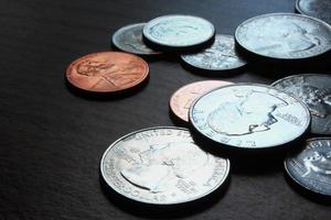 monedas de dólar esparcidas sobre una mesa de madera, foto