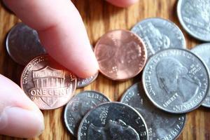 Dollar coins and dollar bills scattered on a wooden table, flat lay dollar coins. photo