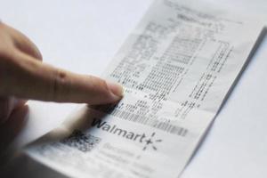 WASHINGTON USA - MARCH 19 2022  Man's hand pointing to taxes on Walmart receipts, taxes payable, tax calculations. photo