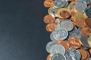 montones de monedas en una mesa negra con espacio. foto