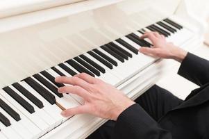 Playing piano. Close-up top view of man playing piano photo
