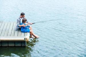 padre e hijo pescando. vista superior de padre e hijo pescando juntos en el muelle foto