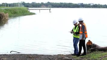 Two environmental engineers are walking along the wastewater treatment site. Wastewater treatment concept.