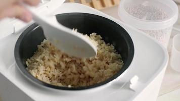 Electric rice cooker on wooden counter-top against ceramic backsplash video