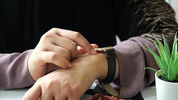 Adult woman checks wrist watch inside video