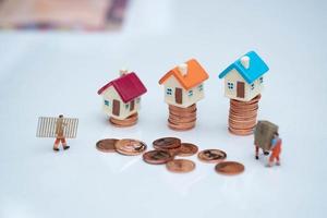 Miniature people business man read a newpaper on house,finance, photo