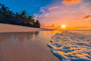 tranquilas vacaciones de verano o paisaje de vacaciones. isla tropical puesta de sol playa vista palmera silueta, cielo tranquilo mar olas. vista exótica de la naturaleza, inspiradora reflexión pacífica del paisaje marino, costa del amanecer foto