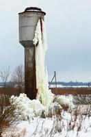 frozen water tower in country field photo