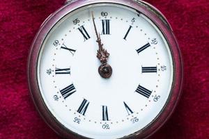 reloj de bolsillo vintage en terciopelo rojo de cerca foto