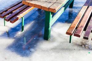 outdoor table and benches frozen in puddle photo