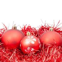 tres adornos navideños rojos y oropel aislado foto