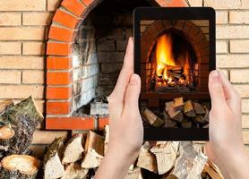 fotografías turísticas fuego en chimenea en tablet pc foto